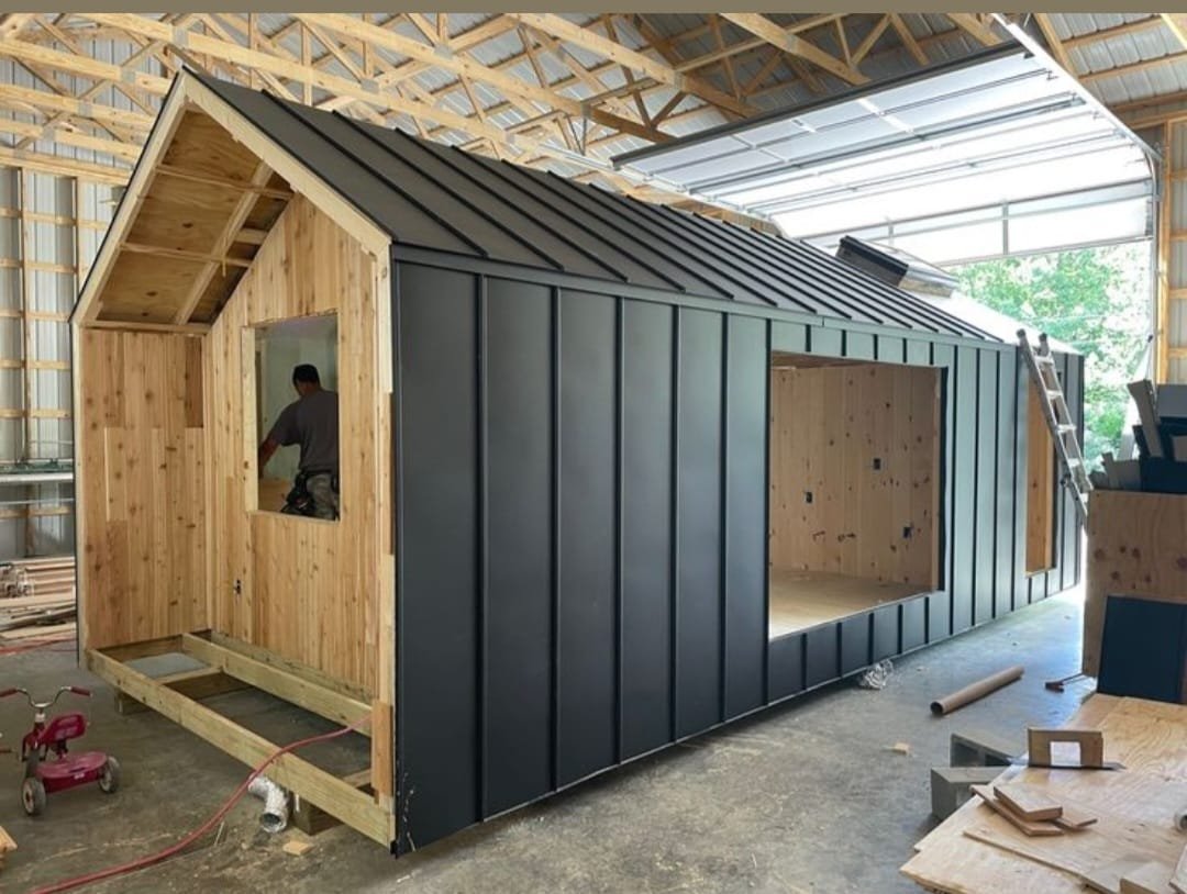 Black metal cladding and roofing being installed